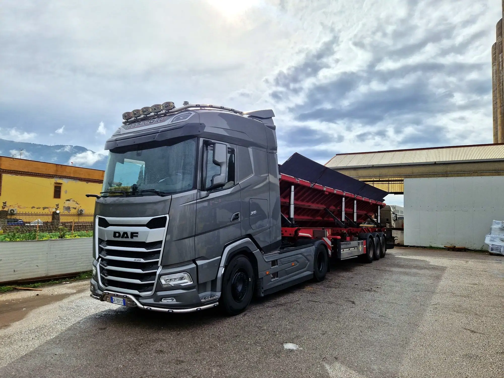 DAF XG Traspogru con semirimorchio rosso a piano inclinato coperto
